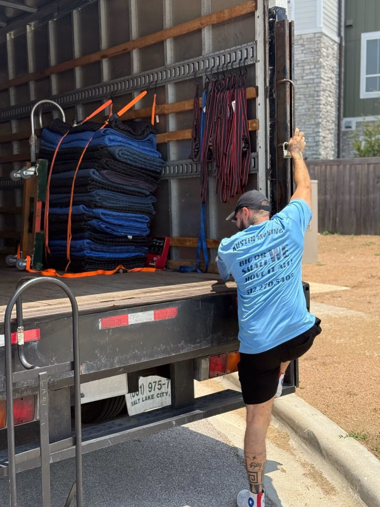 An Austin Moving Company professional safely stepping up into the back of a moving truck.